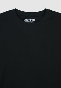 T-shirt nera crop realizzata in cotone, con scollo rotondo e design minimalista. L'etichetta reca la scritta "CROPPED TERRANOVA."
