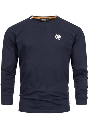 T-paita pitkällä hihaisella navy-sinisenä, joka on valmistettu puuvillasta. Siinä on pyöreä kaula-aukko, tiukat hihansuut ja pieni valkoinen logo rinnassa.