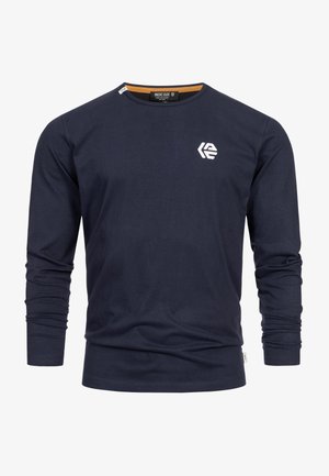 T-paita pitkällä hihaisella navy-sinisenä, joka on valmistettu puuvillasta. Siinä on pyöreä kaula-aukko, tiukat hihansuut ja pieni valkoinen logo rinnassa.