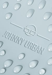 Helleblaue Silikonoberfläche mit erhabenen Wassertropfenmustern und geprägtem "JOHNNY URBAN"-Logo, das Textur und Design betont.