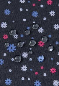 Wassertropfen auf einem dunklen Stoff mit einem floralen Muster in Weiß, Pink und Blau. Die Textur ist gewebt und das Design ist gleichmäßig verteilt.