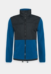 Chaqueta con cremallera azul y negra, con cuello alto, bolsillo en el pecho con cremallera, dos bolsillos laterales y bajo con cordón ajustable. Textura suave.
