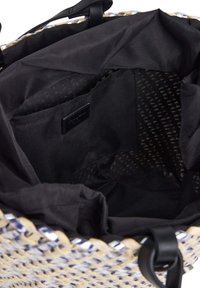Grande borsa tote intrecciata con un design beige e blu. L'interno presenta una fodera in tessuto nero e un'etichetta, con numerose tasche per lo stoccaggio.