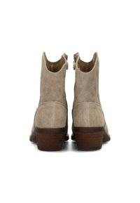 Beige suède enkellaarsjes met een lage gestapelde hak, voorzien van een uitsnijdingsontwerp en decoratieve stiksels op het bovenwerk. Soepele afwerking aan de binnenkant.