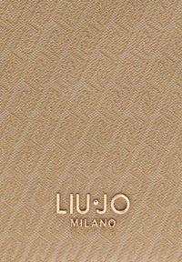Beige, getextureerde stof met diamantpatronen; geperst "LIU·JO MILANO"-logo in goud. Geometrisch ontwerp zorgt voor een subtiele, elegante uitstraling.