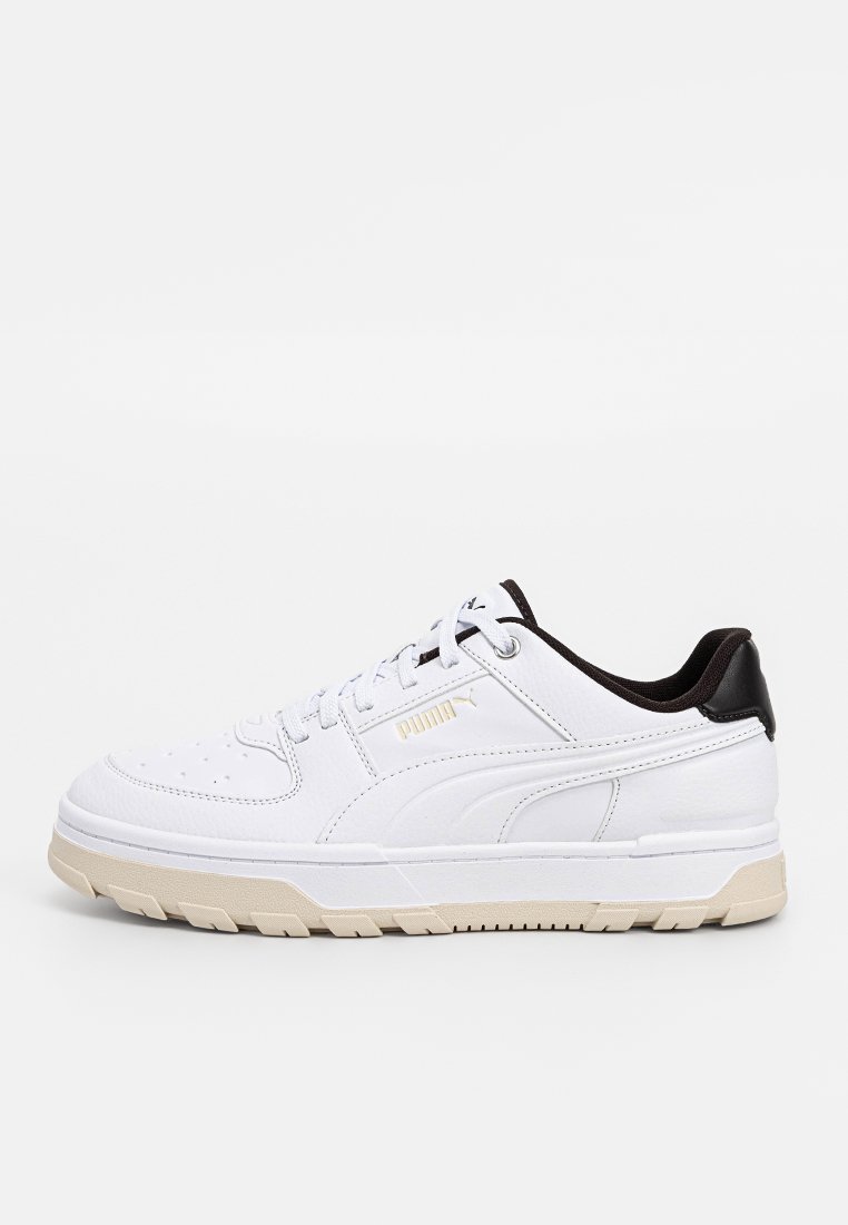 Białe skórzane sneakersy o teksturowanym wykończeniu, z kontrastującą czarną piętą, beżową podeszwą środkową i złotym logo z boku, z zapięciem na sznurówki.