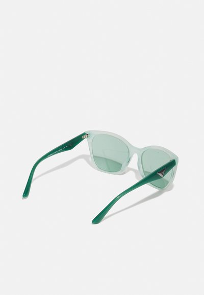 Green-tinted sunglasses with clear, transparent frames and solid green arms. Features a triangular logo accent on the side.