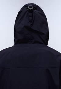 Marineblå vandtæt jakke med hætte med snoretræk, der har en glat overflade, minimalistisk design og en central søm på ryggen.