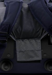 Mochila azul marino con correas acolchadas, una solapa texturizada gris y herrajes negros reforzados. Contiene un tejido interior suave y estampado.