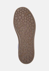Brown rubber shoe sole with circular patterns and textured detailing. "CAMPER" logo and size "42" embossed on the surface.