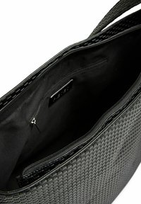 Mustmust kootud kott, millel on tekstureeritud välimus, lukuga sulgemine ja must kangas vooder. Sees on tõmblukuga tasku ja avatud sektsioon.