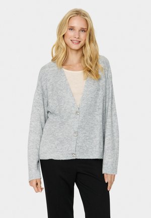 Lichtgrijze cardigan met een v-hals, voorzien van lange mouwen, ribgebreide manchetten en vijf knopen aan de voorkant. Zachte gebreide textuur.