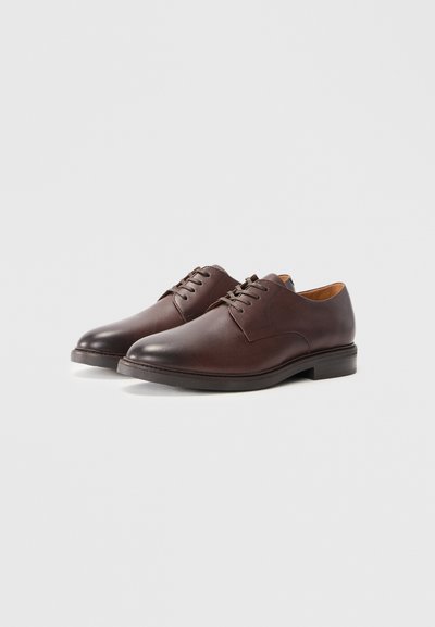Pair of dark brown leather lace-up dress shoes on a white background, showing side and front angles.