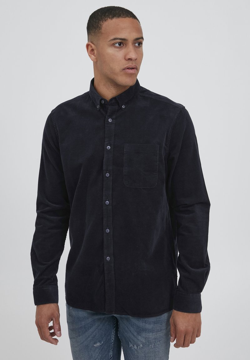 Navy corduroy shirt with button-down collar, single chest pocket, and button closure. Long sleeves with cuff detailing.