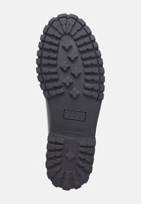 Gummistiefelsohle, schwarz mit tiefen Profilen und Kreuzmustern. Mit eingeprägtem "HENRY STEVENS" und "AUTHENTIC RUBBER". Größe 42.