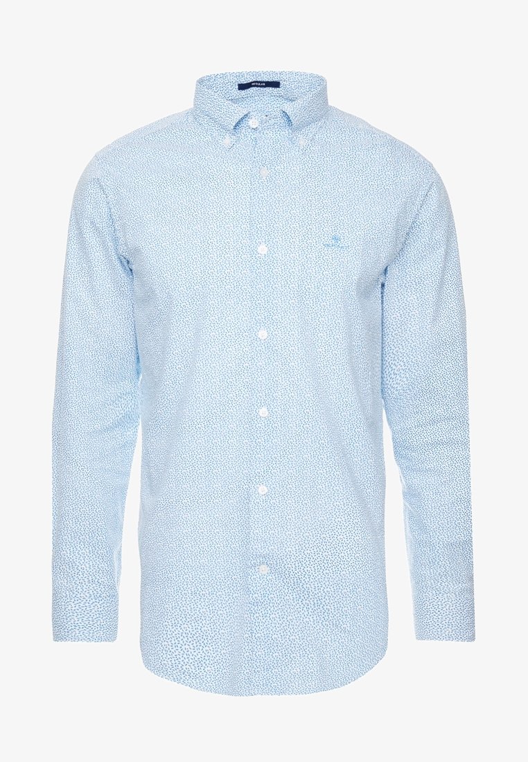 Chemise bleu clair à manches longues avec petit motif abstrait à pois bleu foncé et col boutonné.