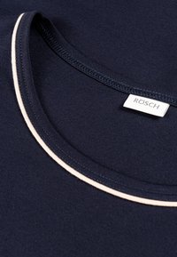 T-shirt blu navy con scollatura tonda e piping beige chiaro a contrasto, realizzato in tessuto liscio con un'etichetta che riporta "RÖSCH."