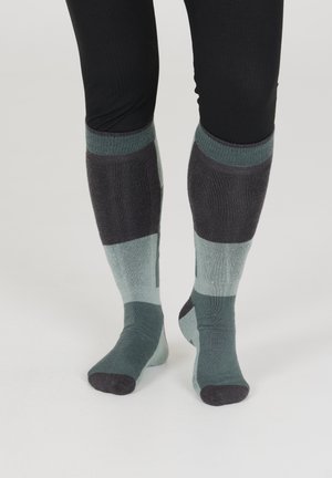 Knæhøje sokker med ribbet tekstur, farveblokdesign i nuancer af teal og mørkegrå, med forstærkede tåspidser og mansjetter.