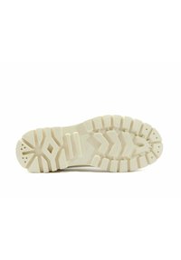 Semelle en caoutchouc blanc avec un motif texturé, comprenant de profondes rainures et des détails de traction, conçue pour la durabilité et l'adhérence.