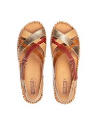 Sandalias marrones y doradas con diseño de tiras cruzadas, hechas de cuero. Presentan un borde trenzado y una plantilla acolchada.