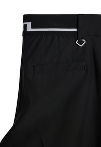 Czarne spodnie o gładkiej fakturze, elastycznym pasie z kontrastującą białą linią oraz jedną kieszenią boczną z subtelnym szwem.