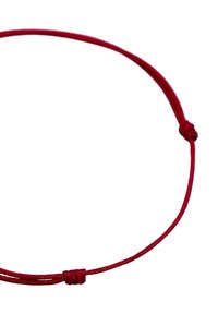 Collier en cordon rouge fabriqué dans un matériau lisse avec un détail de nœud simple, présentant une forme fine et flexible ainsi qu'un design minimaliste.