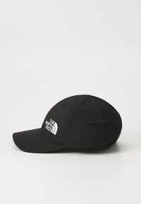 Fekete baseball sapka szövetből, ívelt kívülről. Elöl fehér hímzett logó található, hátul pedig hálós panelek.
