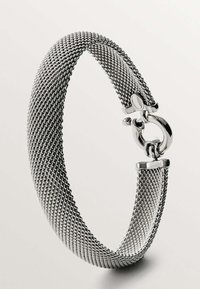 Pulsera de malla plateada con un diseño suave y flexible. Presenta un cierre redondo y una textura uniforme, mostrando intrincados eslabones trenzados.