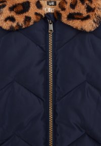 Chaqueta de plumas azul marino con un cuello de pelaje sintético de leopardo marrón, que presenta un cierre frontal de cremallera y una textura de rombos.