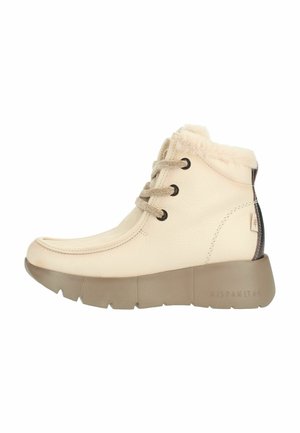 Crèmekleurige enkellaars met dikke beige zool, bontvoering aan de bovenkant, veters aan de voorkant en een donkere streep detail aan de achterkant.