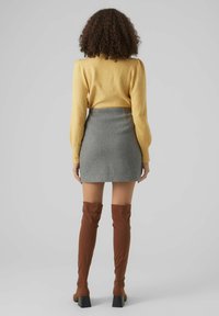Yellow long-sleeve top, gray mini skirt, and brown knee-high boots with square heels. Texture combines soft fabric for top and smooth skirt.