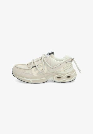 Beige sneakers with mesh upper, suede accents, thick white midsole, and distinctive heel design featuring circular cutouts. Laces are predominantly grey.