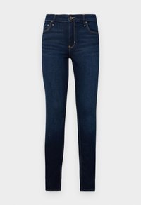 Jeans de denim azul oscuro, ajustados, que presentan un cierre de cremallera, botón en la parte superior y bolsillos frontales con costuras amarillas contrastantes. Textura suave en toda la prenda.
