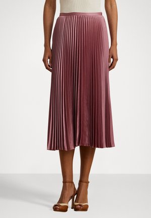 Plisség midi skjørt i myk mauve-stoff med en jevn midje, som har vertikale folder og en flytende silhuett. Brune hælet sandaler.