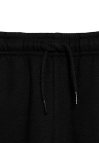 Sorte sweatpants med en taljeelastik, der har snoretræk med metalspids. Materialet er blødt, tekstureret stof med elastik til justerbar pasform.