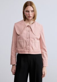 Κοντή ροζ τζιν μπουφάν με μεγάλο γιακά, κλείσιμο με κουμπιά και δύο μπροστινές τσέπες. Ομαλή υφή με ραμμένες διακοσμητικές λεπτομέρειες.