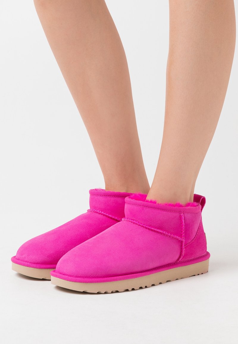 Stivaletti alla caviglia in finta suede rosa con fodera morbida, punta rotonda e suola in gomma beige. Design slip-on con dettaglio di doppia cucitura.