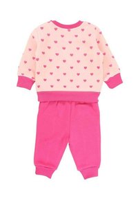 Ensemble en deux pièces composé d'un pull rose clair avec des motifs de cœurs roses et d'un pantalon taille élastique rose, fabriqué en coton doux.