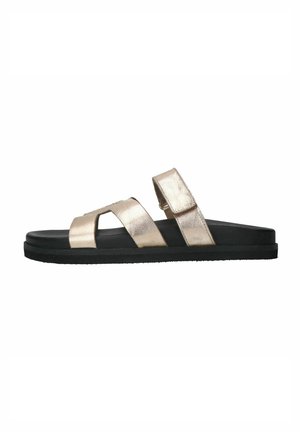 Metallic gold slide sandals with two adjustable straps, black rubber sole, and flat design. Smooth texture with minimalistic style.