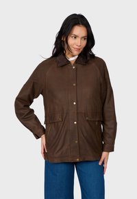 Brązowa skórzana kurtka z kołnierzykiem, z zapięciem na napy, dwoma przednimi kieszeniami oraz miękką teksturą. Posiada luźny krój i rękawy raglanowe.