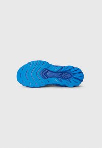 Semelle en caoutchouc bleue avec des rainures et des contours texturés pour une meilleure adhérence. Comprend une zone centrale pour le logo et une transition douce vers la partie supérieure.