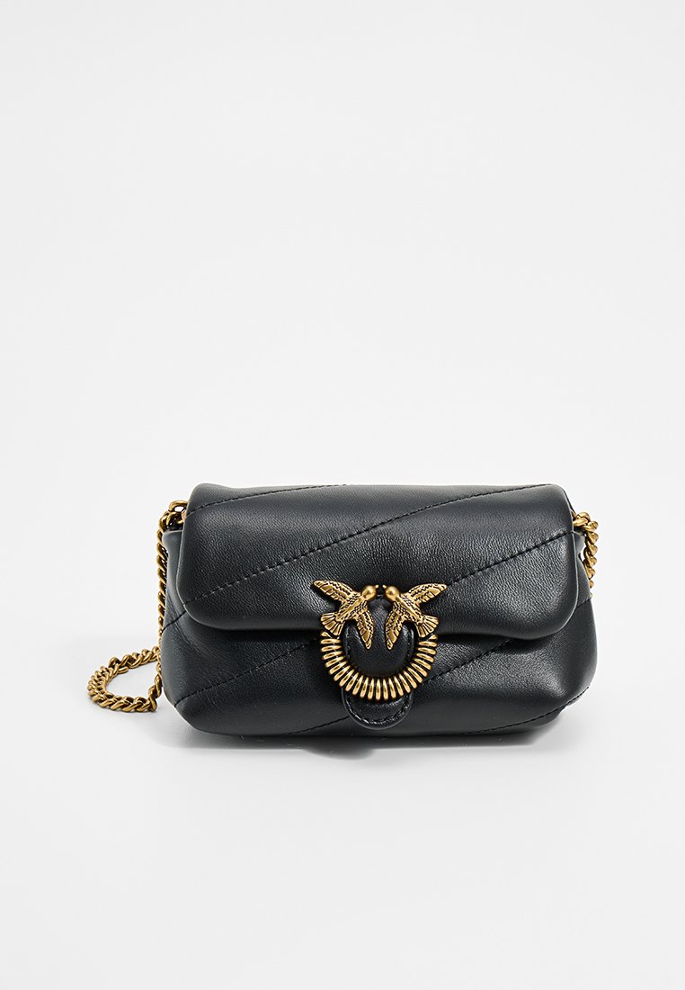 Sac à bandoulière en cuir noir avec texture matelassée, quincaillerie dorée, fermoir décoratif avec motif d'oiseau et bandoulière en chaîne.