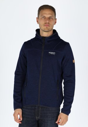 Navyblaue Zip-Hoodie aus strukturiertem Stoff, mit hohem Kragen, zwei mit Reißverschluss versehenen Seitentaschen und einem gestickten Logo auf der Brust.