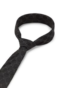 Un nœud papillon noir arbore un motif texturé de cercles entrelacés, confectionné dans un tissu lisse avec un léger éclat. Judicieusement noué à une extrémité.