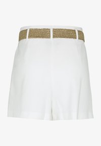 Bílé šortky s texturovaným hnědým pleteným opaskem. Obsahují kapsy a mají zakázkový střih. Bez viditelného značení nebo vzorů. Čistý, minimalistický design.