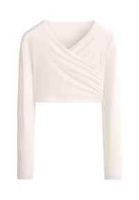 Crop top à manches longues de couleur crème avec un col asymétrique drapé et un détail de tissu froncé sur le côté droit avant.