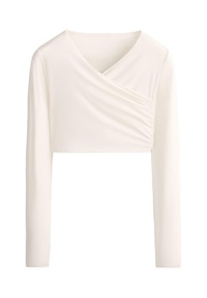 Top corto a maniche lunghe color crema con scollo asimmetrico drappeggiato e dettaglio di tessuto raccolto sul lato destro anteriore.