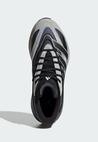 Sportlicher Schuh in Schwarz, Grau und Navy mit einem strukturierten Leder- und Mesh-Obermaterial, kontrastierenden Akzentlinien und schwarzen Schnürsenkeln.