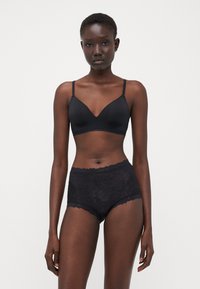 Black lingerie set featuring a smooth fabric bralette with scalloped edges and high-waisted shorts with floral lace pattern.