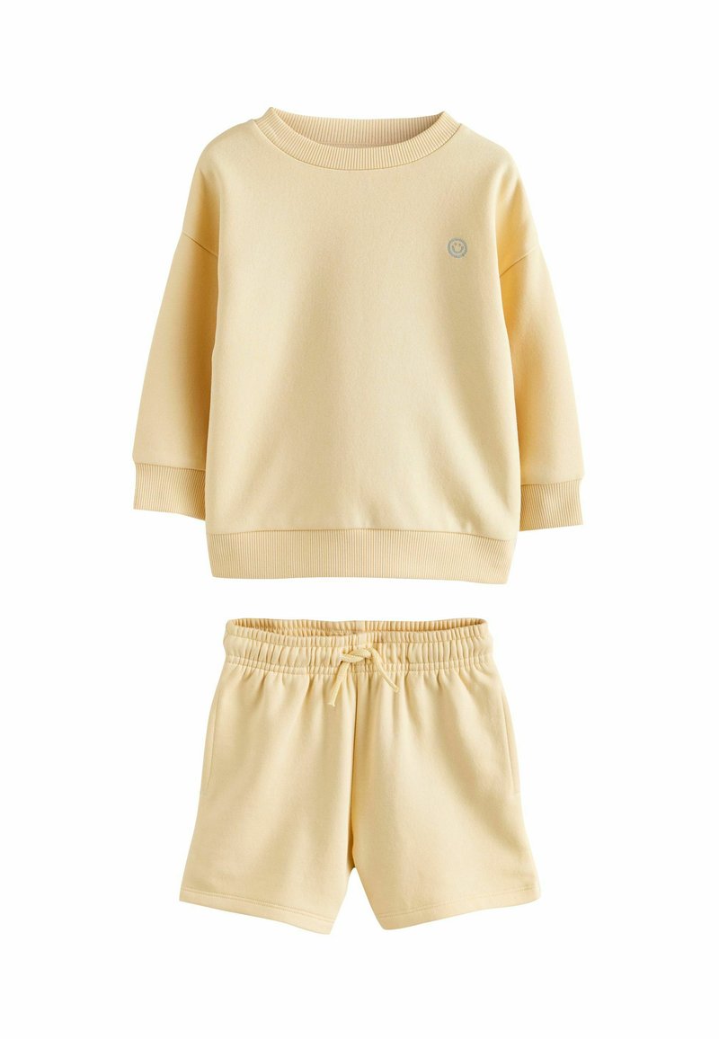 Conjunto de ropa cómoda de algodón amarillo que incluye una sudadera de manga larga con puños acanalados y pantalones cortos a juego con cintura elástica y cordón ajustable.